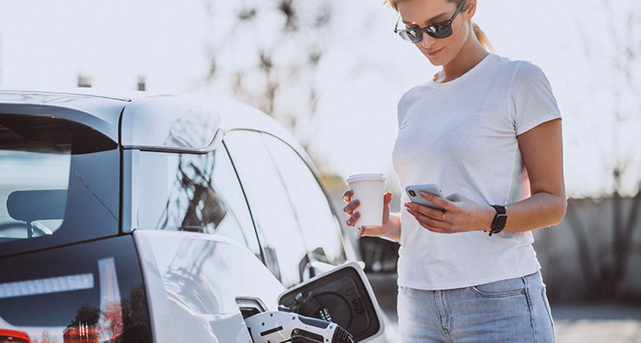 Ragazza che carica un'auto elettrica