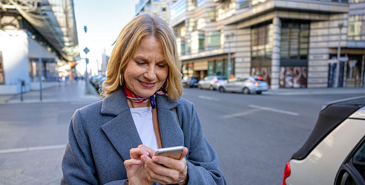 Una signora paga il bollo auto online con lo smartphone